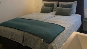 Une chambre à coucher avec un lit, une fenêtre et une baignoire.