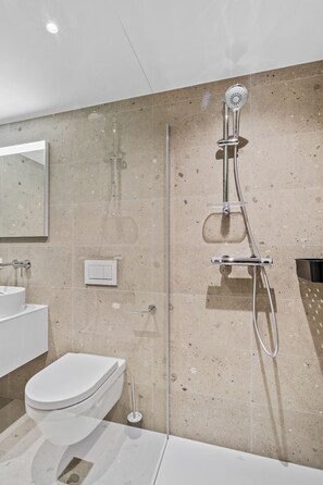 A modern bathroom with a glass-enclosed shower, a white toilet, and a sink. - Clausen Charm Contemporary Retreat ID210 (Luxembourg City)
