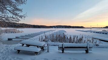 Ett snötäckt utomhusområde med bänkar och en klar himmel.