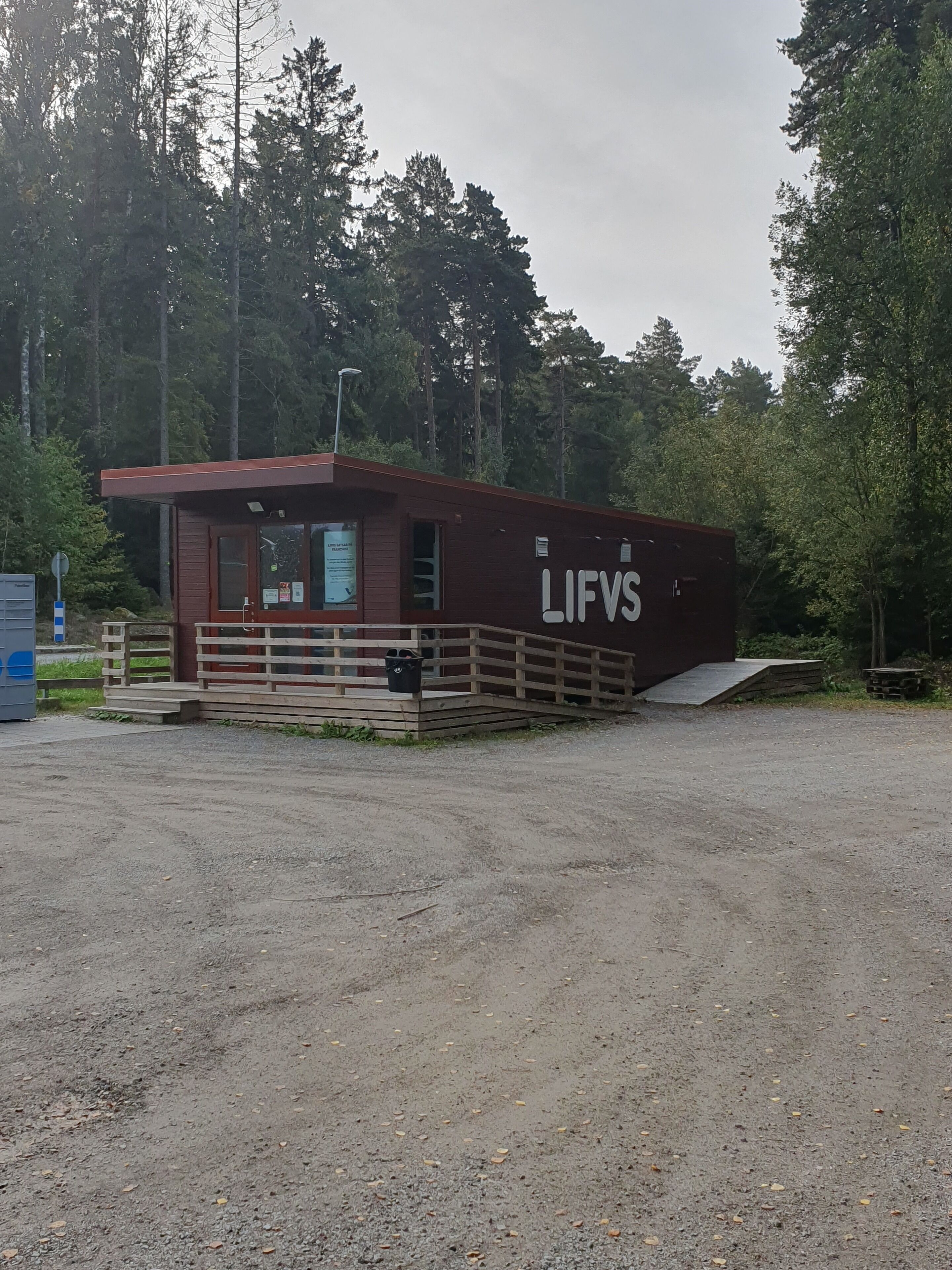 A small, single-story building with a wooden deck and a ramp leading to the entrance. The building has a sign that reads "LIFVS".