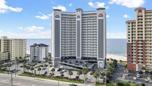 A high-rise hotel with multiple floors, a parking garage, and a beach view. - NEW RENTAL - Updated Beach Front - Seawind 703 - Signature Properties (Gulf Shores)