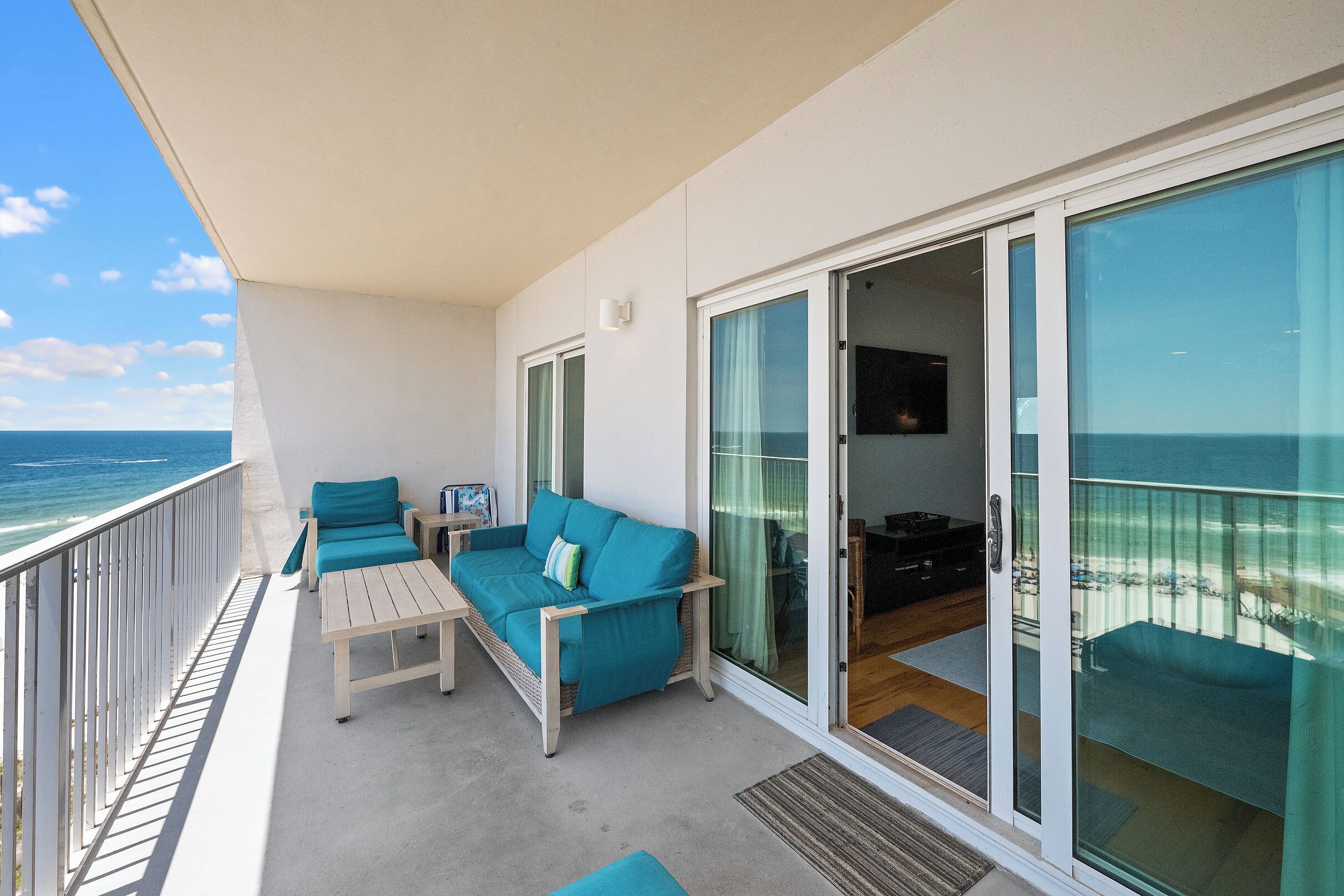 A balcony with a sofa, chairs, and a table.