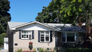 A single-story house with a front porch, a garage, and a well-maintained lawn. - Trillium Bed & Breakfast (Niagara Falls)