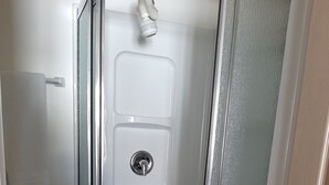 A bathroom with a glass-enclosed shower, a toilet, and a towel rack. - Trillium Bed & Breakfast (Niagara Falls)