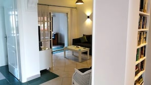 A living room with a sofa, a coffee table, and a bookshelf. - Stunning Spacious One Bed in Delta Sharm (Sharm El Sheikh)
