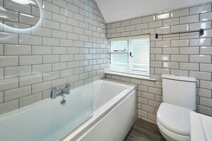 Bathtub, hair dryer, towels, shampoo