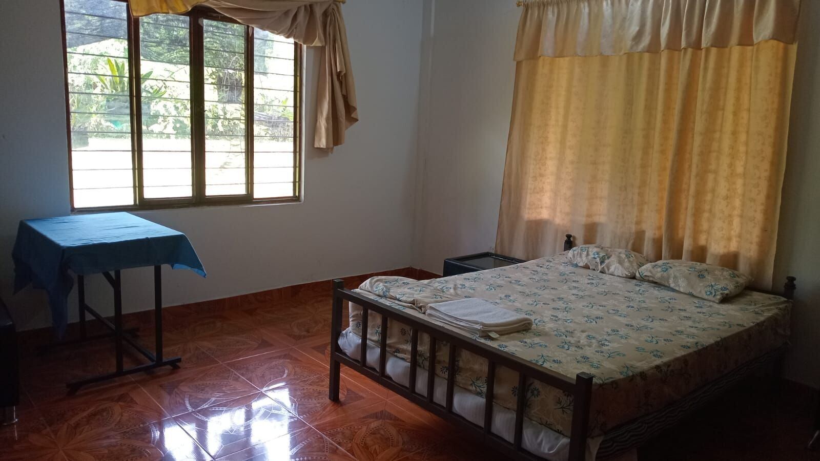 A room with a bed, a table, and a window.