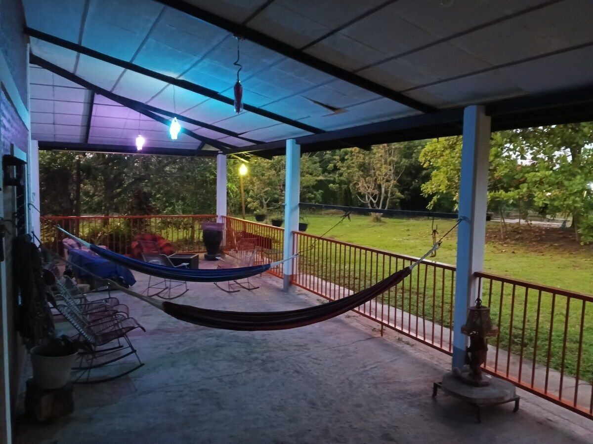 A covered outdoor area with a hammock, chairs, and a statue.
