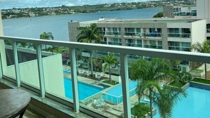 Un balcón con vista a una piscina y una extensión de agua.