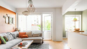 Un salon moderne avec un canapé, une table basse et un coin repas doté d’un comptoir de cuisine.