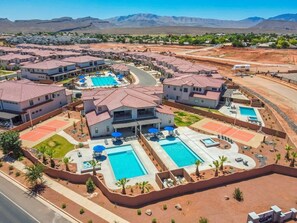 A residential area with multiple houses, a swimming pool, tennis courts, and a mountain backdrop. - 2 Private Pools, Hot Tubs, Sport Courts, Fire Pits! (Santa Clara)