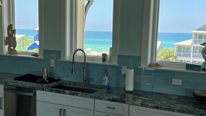 A kitchen with a view of the ocean, a sink, and a countertop with a bottle of hand soap. - 5BR, Beach View, Elevator, Comm Pool, North Cape (Cape San Blas)