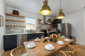 Eine moderne Küche mit dunklen Schränken, Edelstahlgeräten und Holzregalen.