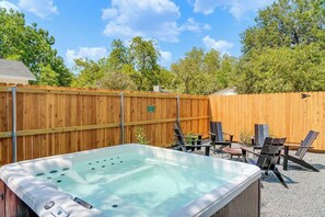 A hot tub with a wooden fence and outdoor seating. - The Viognier: Hot-Tub+Fire Pit + Walk to Main St. (Fredericksburg)