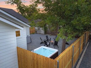 A backyard with a hot tub, outdoor seating, and a wooden fence. - The Malbec: 3 Blocks to Main St w/Hot-Tub+Firepit! (Fredericksburg)