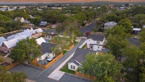 An aerial view of a residential area with houses, streets, and a large open space with a playground.