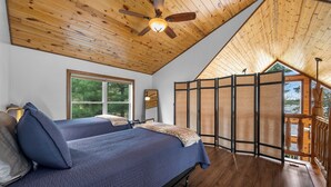 A bedroom with two beds, a ceiling fan, a large window, and a view of the outdoors. - Lakeside: 4 Kings, Room4Groups, Hot Tub, Dock, Firewood (Brainerd)