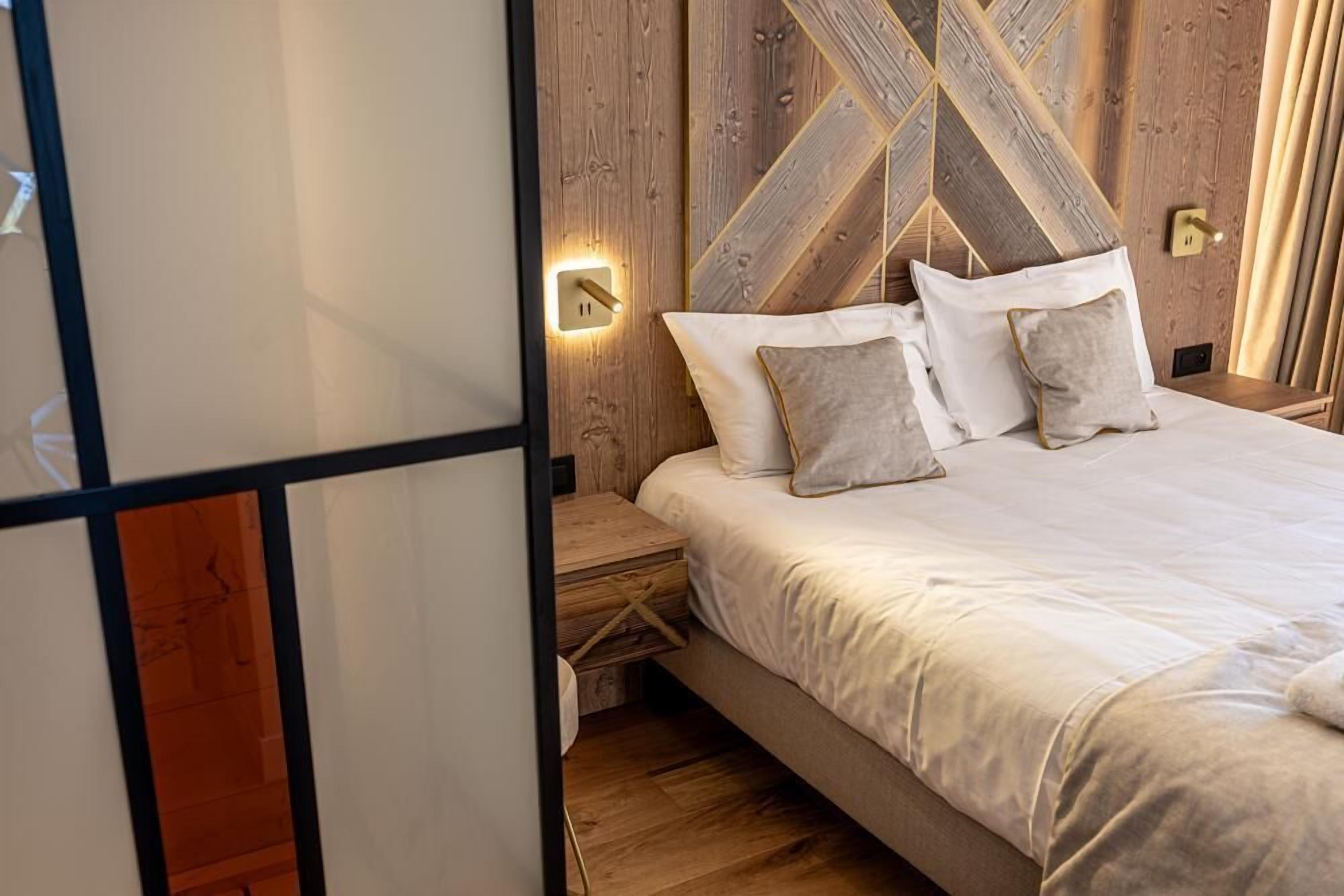 Een slaapkamer met een houten hoofdbord, een nachtkastje en een nachttafel.