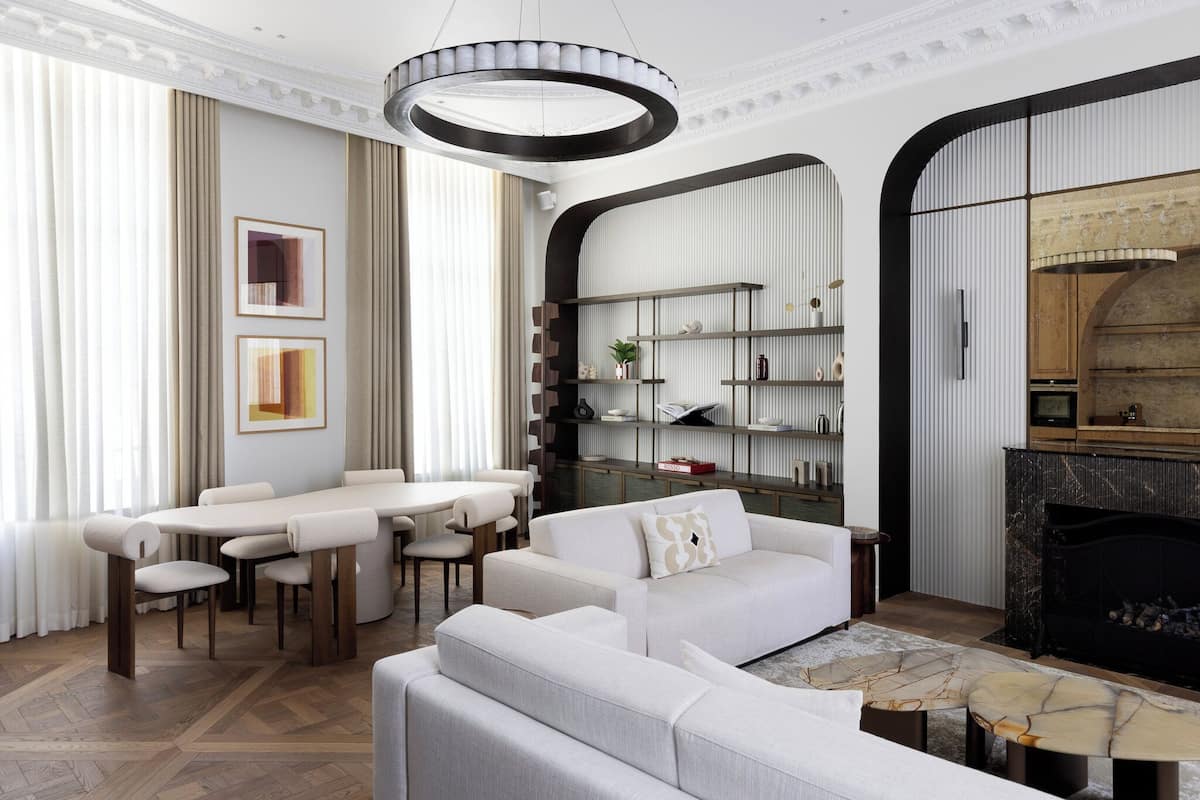 A modern living room with a fireplace, a dining area, and a bookshelf.
