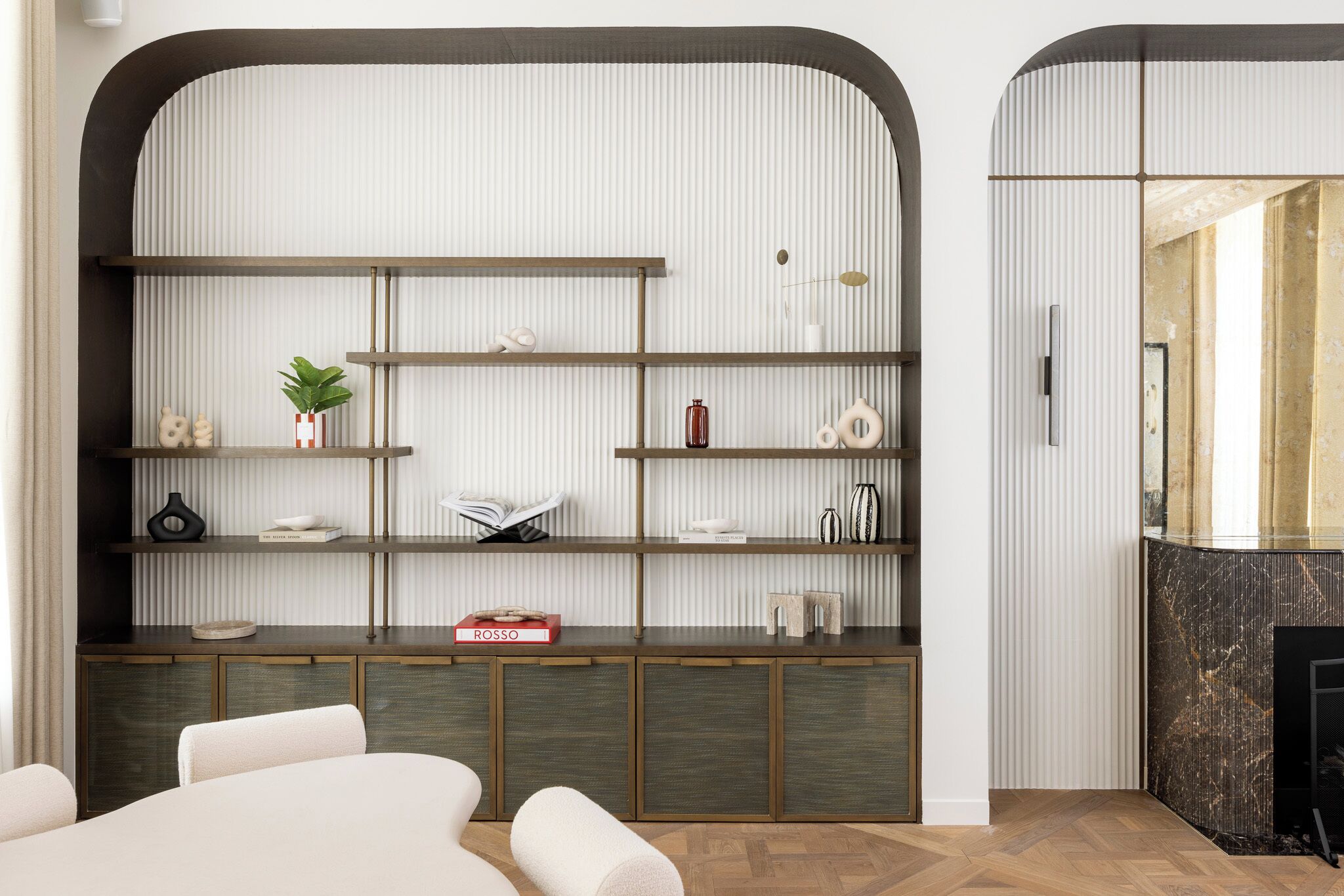 A modern living room with a built-in bookshelf, a fireplace, and a seating area.