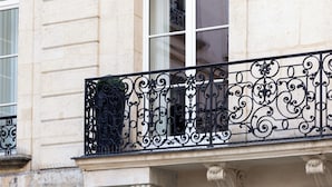 A building facade with a balcony featuring ornate wrought iron railings and a classical architectural style. - HIGHSTAY - Luxury Serviced Apartments - Le Marais (Paris)