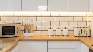 A modern kitchen with a microwave, toaster, and knife block on the counter. - Edinburgh Aparthotel (Edinburgh)