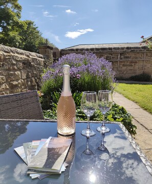 A table with a bottle, two glasses, and brochures.