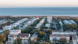 A coastal residential area with houses and a beach in the background.