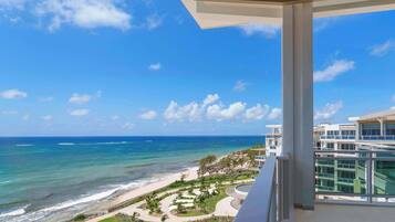 A balcony with a view of a beach and ocean.