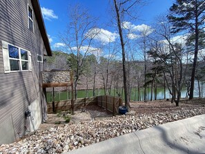 Enjoy a serene lake view from the deck, surrounded by a stone accent wall and a wooden fence.