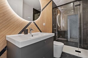 Appartement | Badkamer | Een douche, gratis toiletartikelen, een haardroger, handdoeken