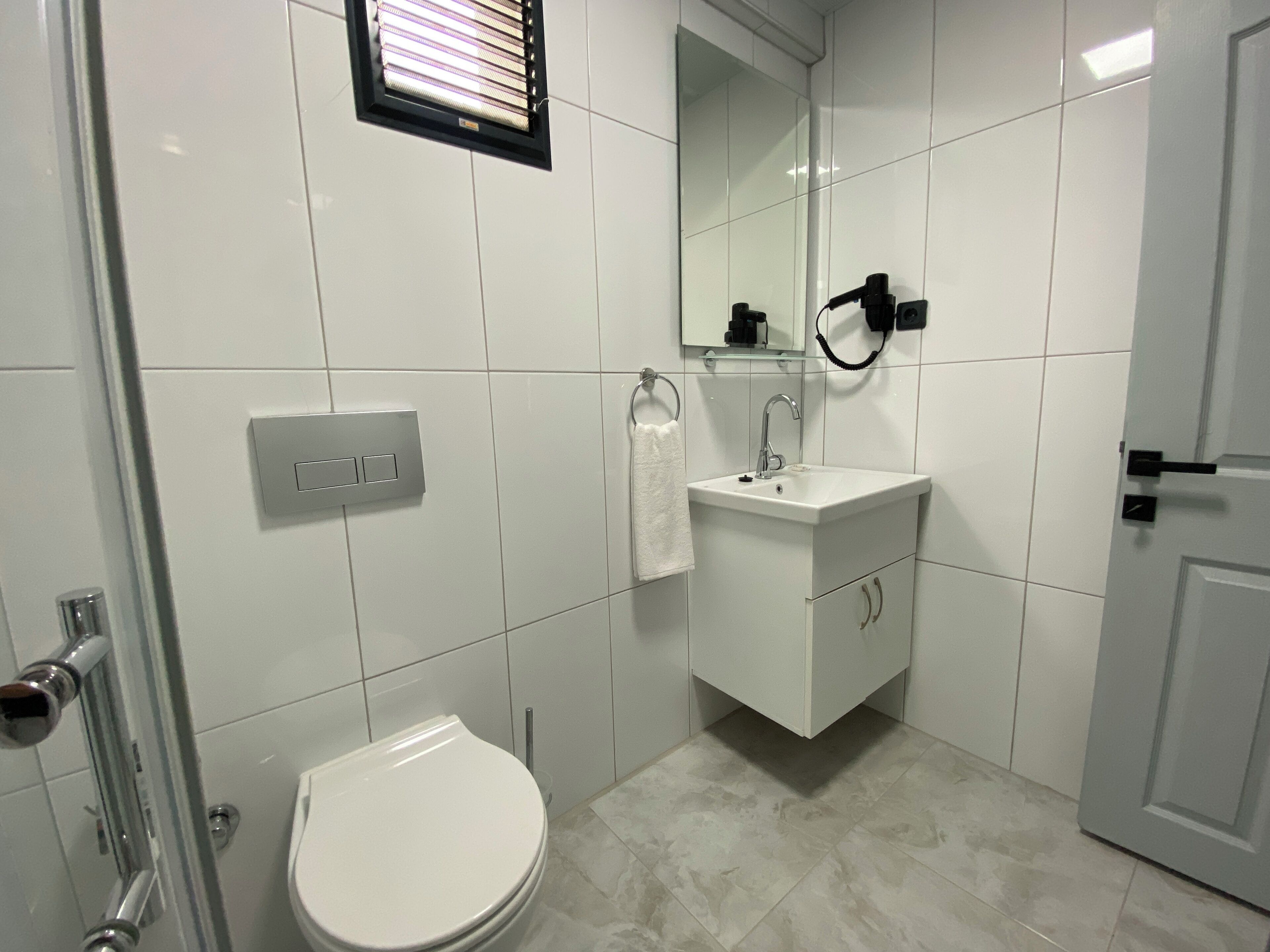 A modern bathroom with a toilet, sink, and shower.