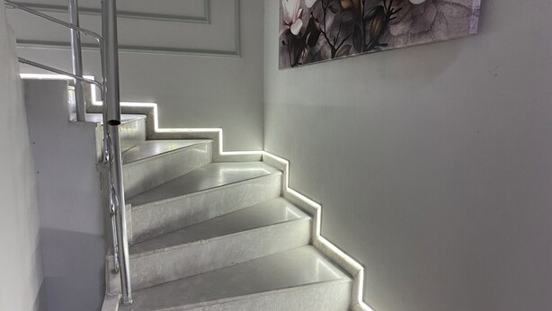 A staircase with a metal handrail and a red carpet at the bottom. - Eraliz (Izmir)