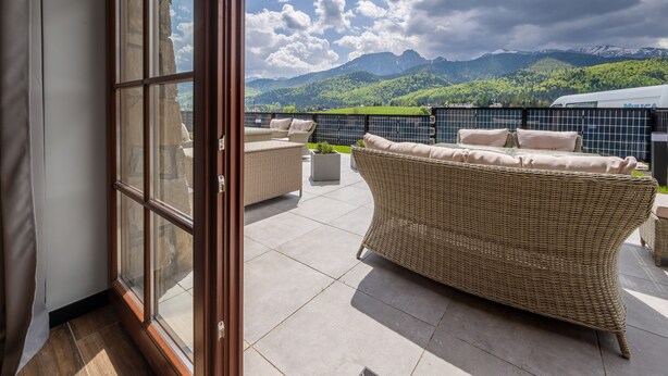 A balcony with wicker furniture and a view of mountains. - Korona Giewontu 3 (Koscielisko)