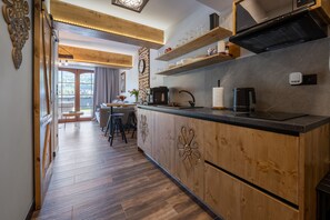 Een moderne keuken met houten kastjes, een zwart aanrecht en inbouwplanken.