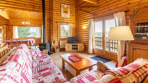 A log cabin interior with a sofa set, a television, a fireplace, and a dining area. - Chalet les deux marmottes - Vue montagne (Bolquère)