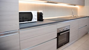 A modern kitchen with a microwave, coffee maker, and oven. - Infinity Apartment by Wonderful Italy (Bellagio)