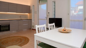 A modern kitchen with grey cabinets, a built-in oven, and a TV on the wall. - Infinity Apartment by Wonderful Italy (Bellagio)
