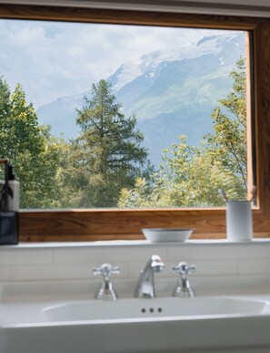 A bathroom with a window view of a mountain landscape.