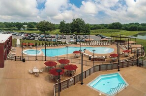 A rooftop pool area with multiple pools, lounge chairs, and umbrellas. - Walker's Bluff Casino Resort (Carterville)