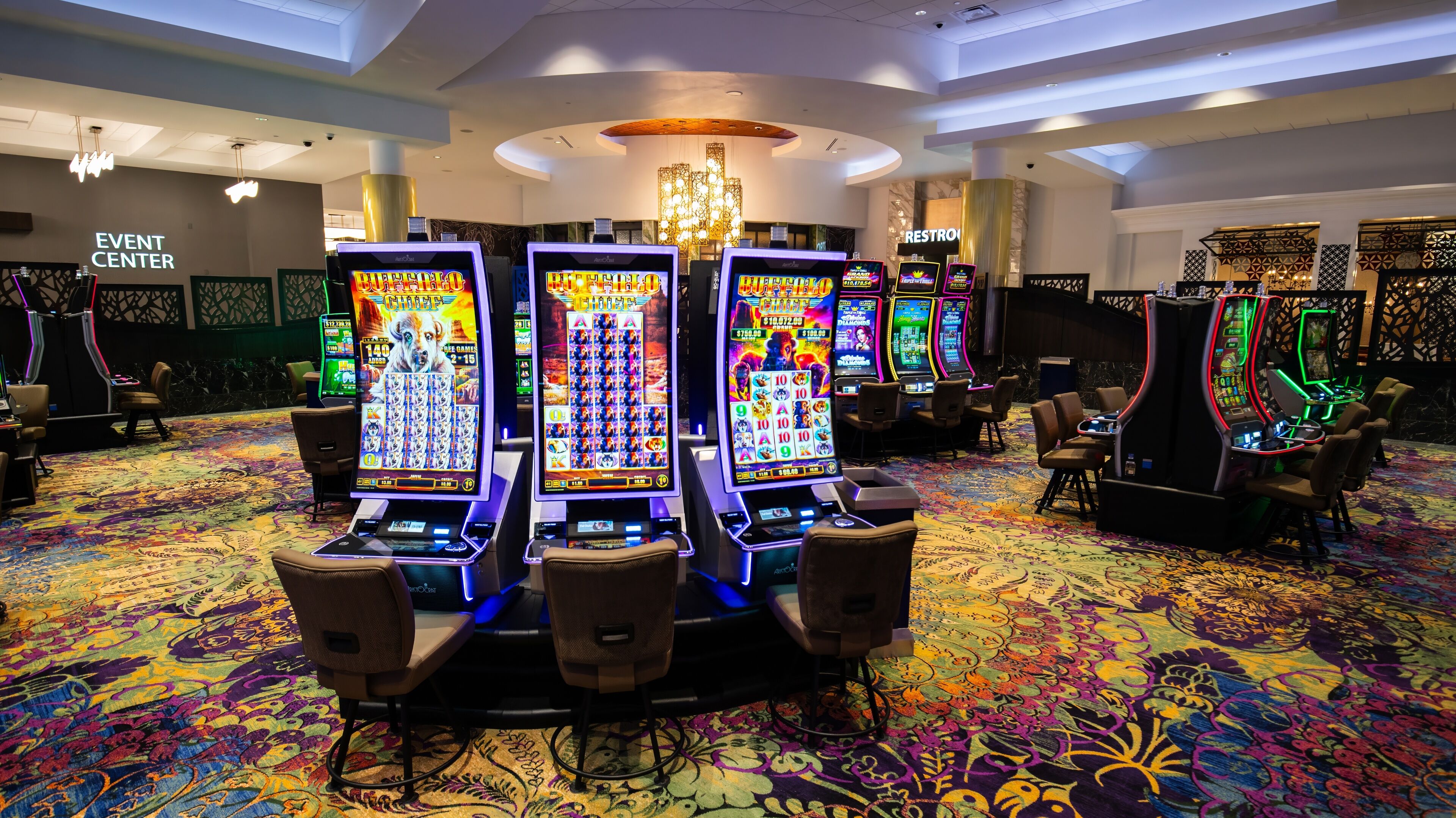 A casino area with slot machines and a carpeted floor.