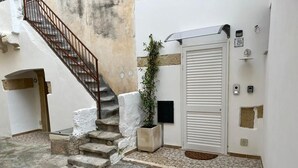 A narrow stairway leading to a door, a small potted plant, and a wall-mounted intercom. - Studio apartment on padreterno street in nardò to relax, 5 minutes from the beach  (Nardò)