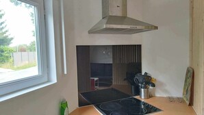 Una cocina compacta con estufa a gas, un lavabo y un ventanal que proporciona luz natural.