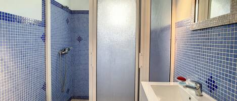 Ein Badezimmer mit Dusche, Waschbecken und Toilette.
