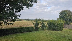 A rural landscape with a grassy field, a wooden fence, and trees. - Charming Studio Rutland Point Holiday or Work (Oakham)