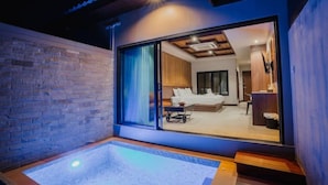A modern room with a large sliding glass door leading to a bedroom.