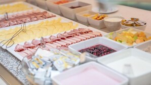A buffet with various food items including meats, cheeses, and fruits. - Hotel Orangerie (Vienna)