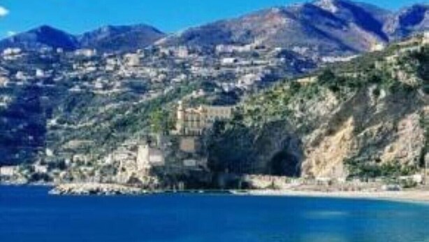 A coastal town with a clear blue sea, rocky shoreline, and mountainous backdrop. - Cozy and lovely apartment, a stone's throw from the sea and 200mt from the center. (Maiori)