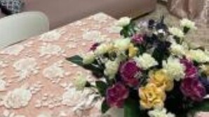 A room with a bed, a pink sofa, a painting on the wall, and a bouquet of flowers on the bed. - Cozy and lovely apartment, a stone's throw from the sea and 200mt from the center. (Maiori)