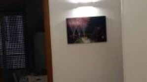 A room with a patterned carpet, a framed picture on the wall, and a door leading to another room. - Cozy and lovely apartment, a stone's throw from the sea and 200mt from the center. (Maiori)